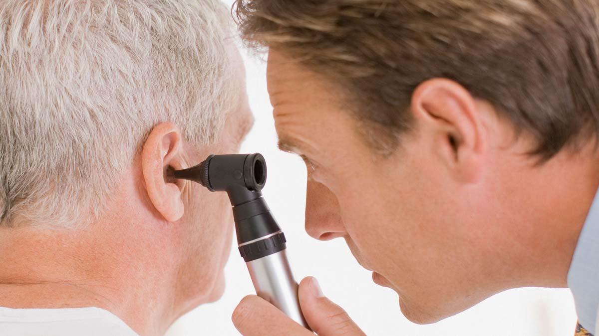 Man examines someone's ear